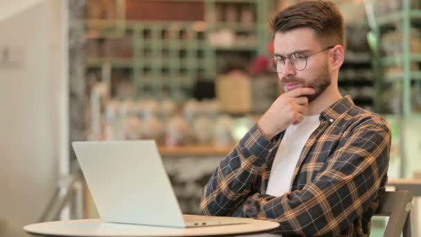 Pensive jonge man met behulp van laptop in Cafe  - Video
