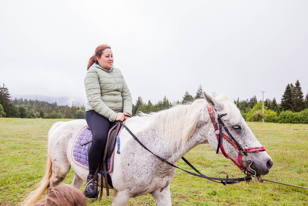 Passeios a cavalo - mulher montar um cavalo no rancho, paisagem rural, luz do dia
 - Foto, Imagem
