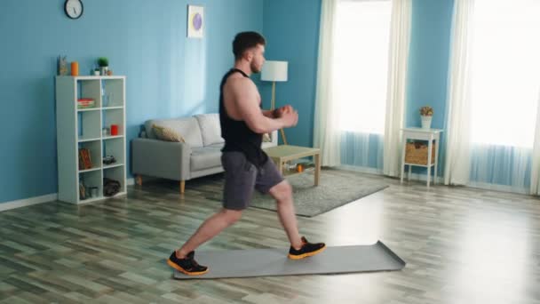 Young Man Is Training in Living Room - Séquence, vidéo