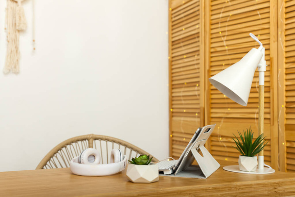 Schreibtisch des kreativen Arbeiters mit Tablet-PC, Kopfhörer, Sukkulenten, Tischlampe. Moderner kreativer Arbeitsplatz. - Foto, Bild