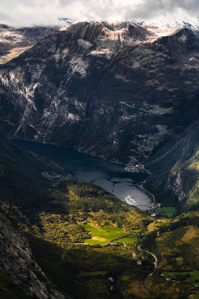 Geiranger fjord seen from Dalsnibba mountain top with the big cruise ship looking small in the middle of big mountains and the fjord - Foto, imagen