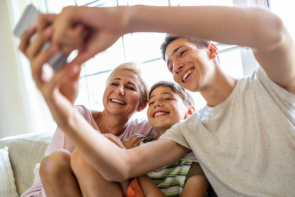 Mother with her two sons taking selfie at home - Foto, Bild