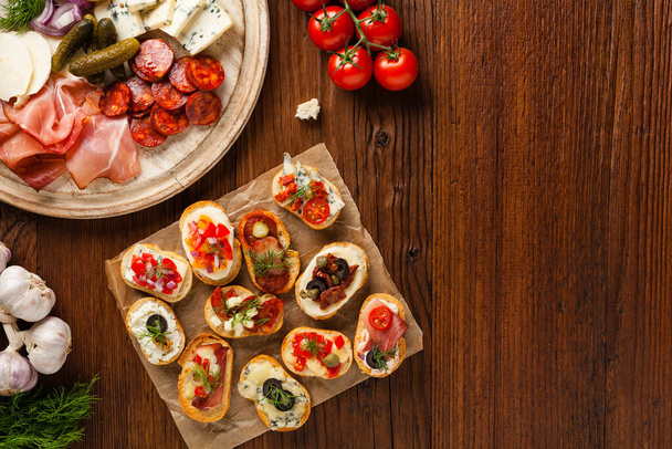 Crostini with different toppings on wooden background. Delicious appetizers. Top view. - Foto, immagini