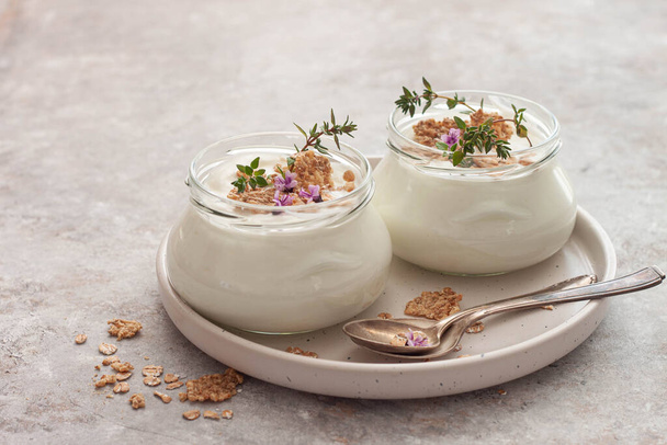 Naturalny jogurt organiczny domowej roboty z granolą i owsianką w szklanych słoikach - Zdjęcie, obraz