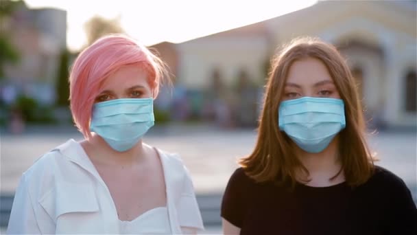 Retrato de duas jovens senhoras tirando máscaras médicas
 - Filmagem, Vídeo