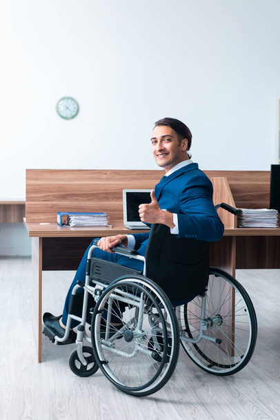 Νεαρός άνδρας υπάλληλος σε αναπηρική καρέκλα - Φωτογραφία, εικόνα