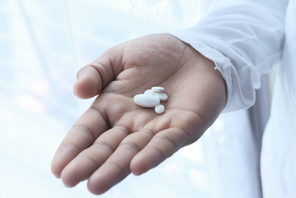 close up of white pills on palm of hand  - Photo, Image
