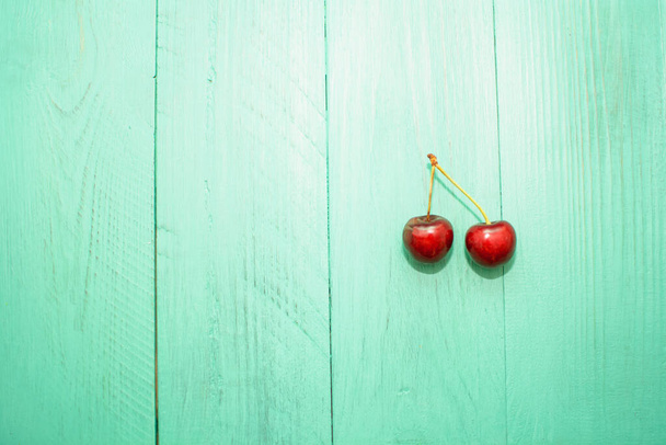 Ripe sweet cherries on a wooden background - Fotografie, Obrázek