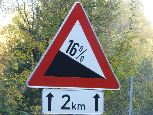 交通標識勾配16%前方の急な道路赤三角形背景の木 - 写真・画像