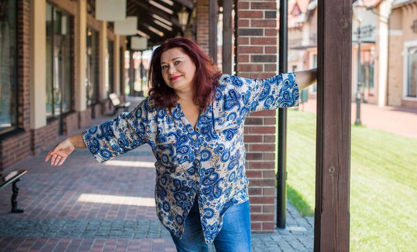 Mature plus size woman, American or European appearance walks and the  enjoying life. Lady with excess weight, stylishly dressed at the city park .Natural beauty - Foto, imagen