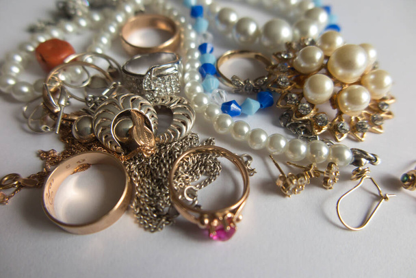various jewelry items such as earrings, beads, pearls, chains, crosses, wedding rings, rings and more - Photo, Image