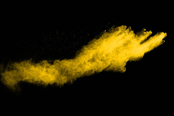 Freeze motion of yellow dust explosion isolated on black background. - Fotografie, Obrázek