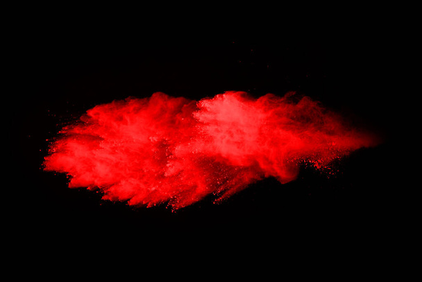 abstrakcyjna eksplozja czerwonego proszku na czarnym tle.abstrakcyjny czerwony proszek rozbryzgany na czarnym tle. Zamrozić ruch czerwonego proszku eksplodującego. - Zdjęcie, obraz