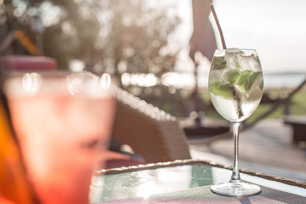 Läpinäkyvä cocktail kuplia ja kalkkia pöydällä auringonlaskun aikaan. Ilmakehän kesän juoma edessä valo lähellä. Valko-Venäjä, Minsk - Valokuva, kuva