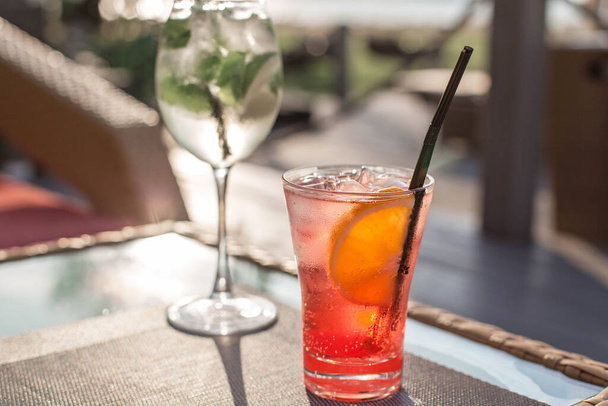 Transparenter Cocktail mit Blasen und Limette auf dem Tisch bei Sonnenuntergang. Stimmungsvoller Sommerdrink im Scheinwerferlicht aus nächster Nähe. Weißrussland, Minsk - Foto, Bild