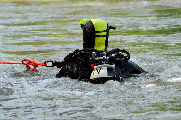 Rettungstaucher der Feuerwehr mit Sicherungsseil und Sauerstoffflasche im Wasser - Foto, Bild