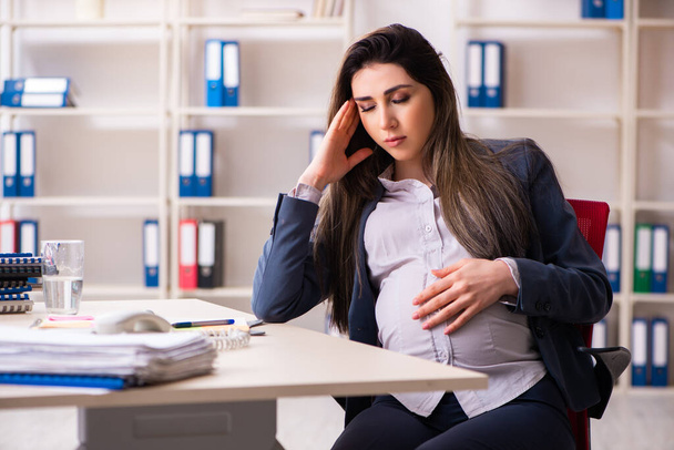 Young pregnant woman working in the office - Foto, Imagen