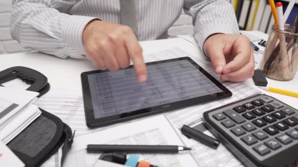 Business analysis and accounting concept - businessman working with document, spreadsheet, using calculator, tablet pc. Office desk closeup.  - Footage, Video