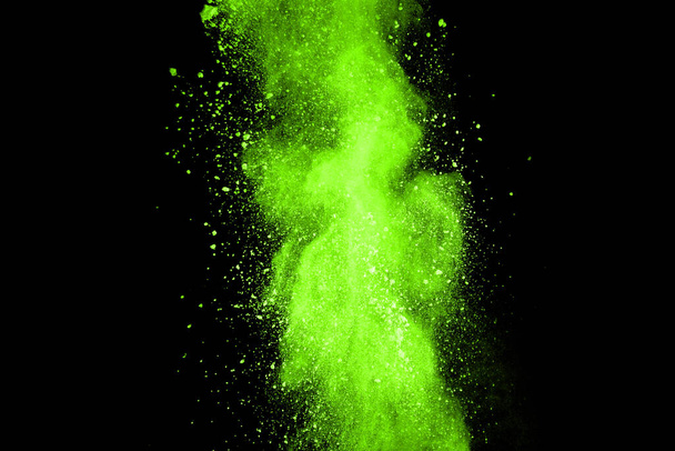 抽象的な塵爆発の動きは黒を背景に緑色に凍結した。黒の背景に粉末グリーンの動きを停止します。黒の背景に爆発性粉末緑. - 写真・画像