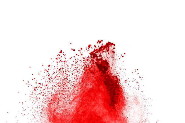Freeze motion of red powder exploding, isolated on white background. Abstract design of red dust cloud. Particles explosion screen saver, wallpaper - Photo, Image