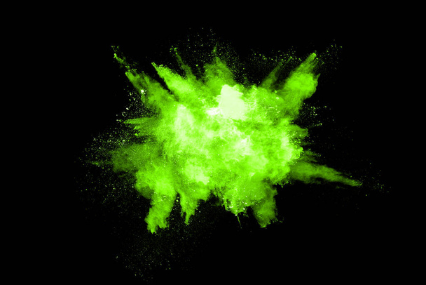 Ruch abstrakcyjnej eksplozji pyłu zamrożony zielony na czarnym tle. Zatrzymać ruch sproszkowanego zieleni na czarnym tle. Proszek wybuchowy zielony na czarnym tle. - Zdjęcie, obraz