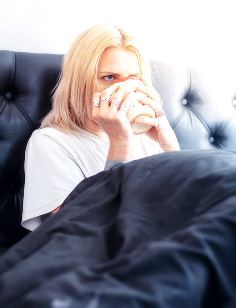 Blondýny žena pije horký nápoj v posteli - Fotografie, Obrázek