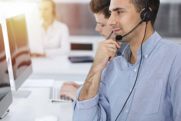Call center. Group of casual dressed operators at work. Adult businessman in headset at customer service office. Telesales in business - Foto, immagini