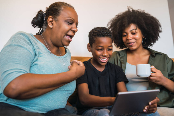 Portrait of African American grandmother, mother and son taking a selfie with digital tablet at home. Technology and lifestyle concept. - Photo, Image