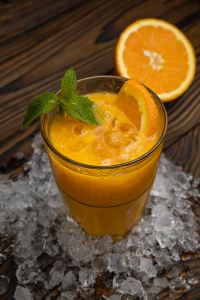Cocktail. Orange juice with mint and ice rustic wooden table - Foto, imagen