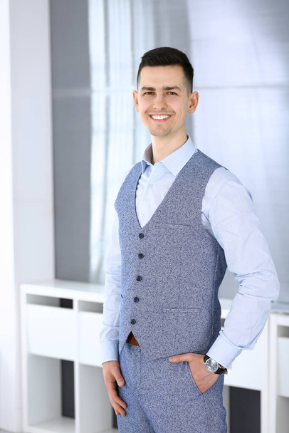 Businessman standing and looking at camera in office. Headshot of casual dressed guy - Фото, зображення