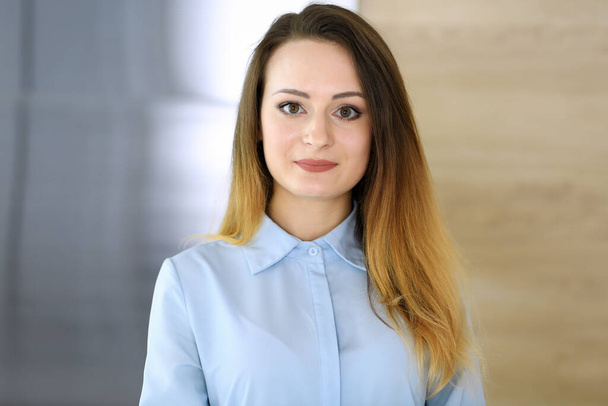 Business woman headshot at workplace in modern office. Unknown businesswoman standing straight with arms crossed. Young accountant or secretary looks good - Φωτογραφία, εικόνα
