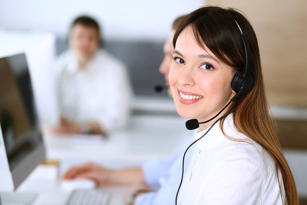 Call center. Group of diverse operators at work. Focus on beautiful asian woman in headset at customer service office. Business concept - Valokuva, kuva