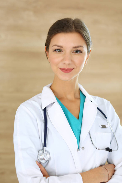 Doctor woman standing and looking at camera. Physician at work, studio portrait at medical background. Medicine and health care concept - Photo, image