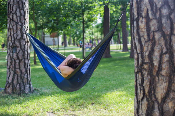 Young guy has a rest in summer in a hammock - Photo, Image