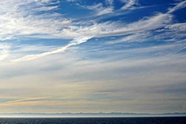 Vederachtige wolken boven de noordelijke Stille Oceaan, bergen in het noordwesten van de Stille Oceaan. - Foto, afbeelding