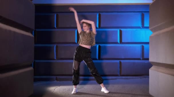 fiatal lány táncos táncol modern utcai tánc a falnak késő este. Kortárs koreográfia. Ifjúsági szubkultúra - Felvétel, videó