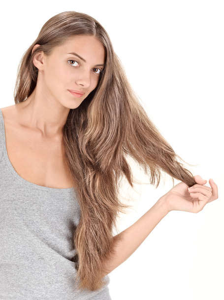 Young brunette beautiful lady playing with long hairs on white - Photo, image
