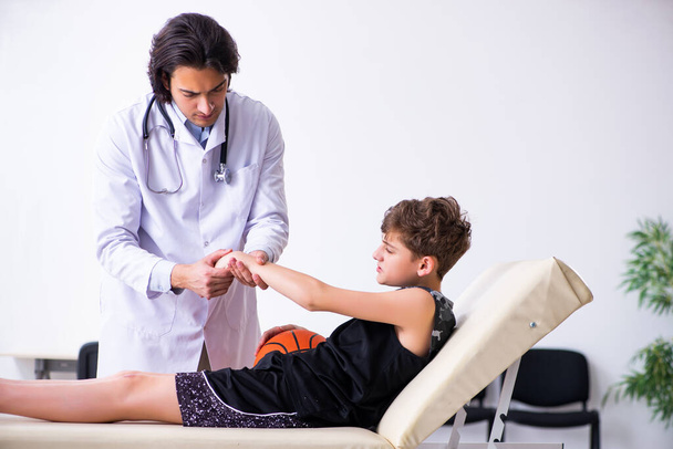 Garçon joueur de basket visitant jeune médecin traumatologue
 - Photo, image
