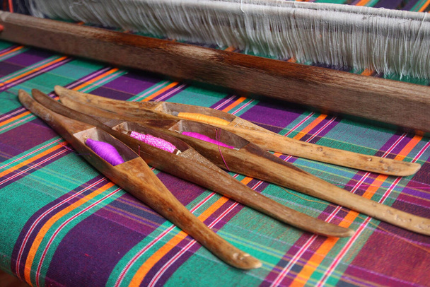 bobina de madeira em tecido de seda, tecelagem tradicional de seda tailandesa
 - Foto, Imagem