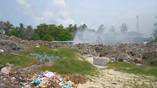 Dikke witte giftige rook rolt uit een enorme stortplaats brandend plastic afval. - Video
