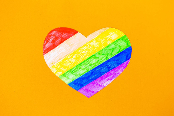 Turuncu arkaplanda lgbtq renginde kalp, üst görünüm - Fotoğraf, Görsel