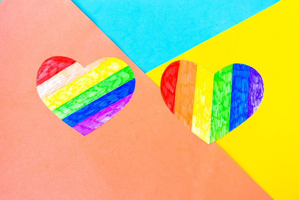Δύο καρδιές σε lgbtq χρώματα και μολύβια χρώμα στο φόντο χρώμα, πάνω όψη, αντίγραφο χώρου - Φωτογραφία, εικόνα