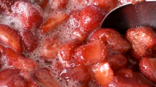 A folyamat, hogy eper lekvár saját gyümölcslé hozzáadásával cukor egy nyitott tálban egy gáztűzhely makró videó forgatás - Felvétel, videó