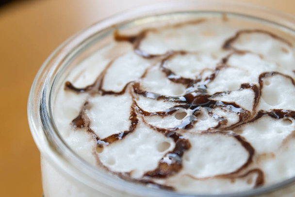 Arte de café y chocolate Mocha sobre leche espumosa en el marco derecho sobre fondo de madera
 - Foto, Imagen