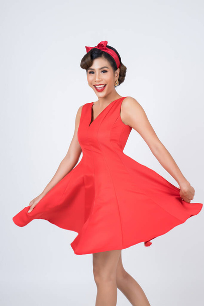 Beautiful woman wearing red dress in studio - 写真・画像