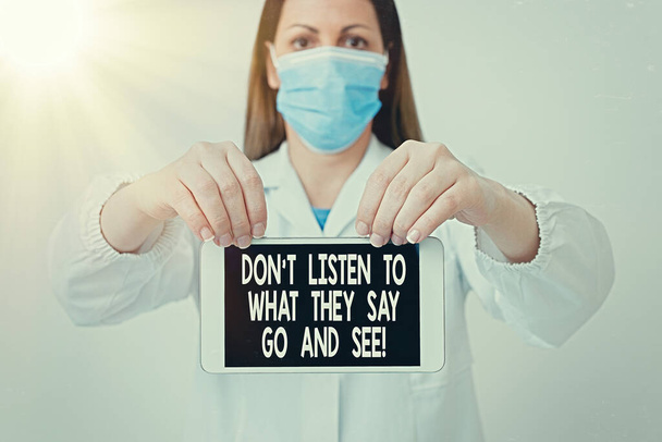 Text sign showing Dont Listen To What They Say Go And See. Conceptual photo to travel and explore the world Laboratory technician featuring empty sticker paper accessories smartphone. - Photo, Image