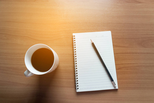 Planejamento de viagens no calendário e use o post-it para anotar com uma xícara de café em uma mesa de madeira
 - Foto, Imagem