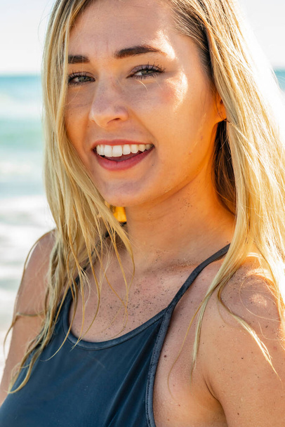 Een prachtige jonge blonde vrouw geniet van een dag aan het strand alleen - Foto, afbeelding