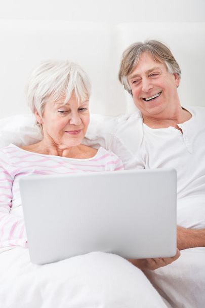 Senior Couple On Bed Looking At Laptop - Zdjęcie, obraz