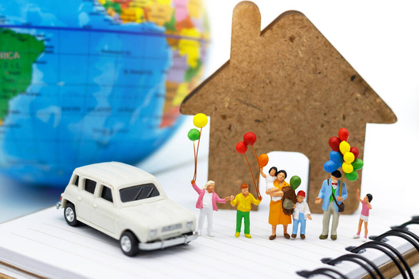 Miniature people, family and children enjoy with colorful balloons, car, house and globe on the book, happy family day concept. - Fotografie, Obrázek